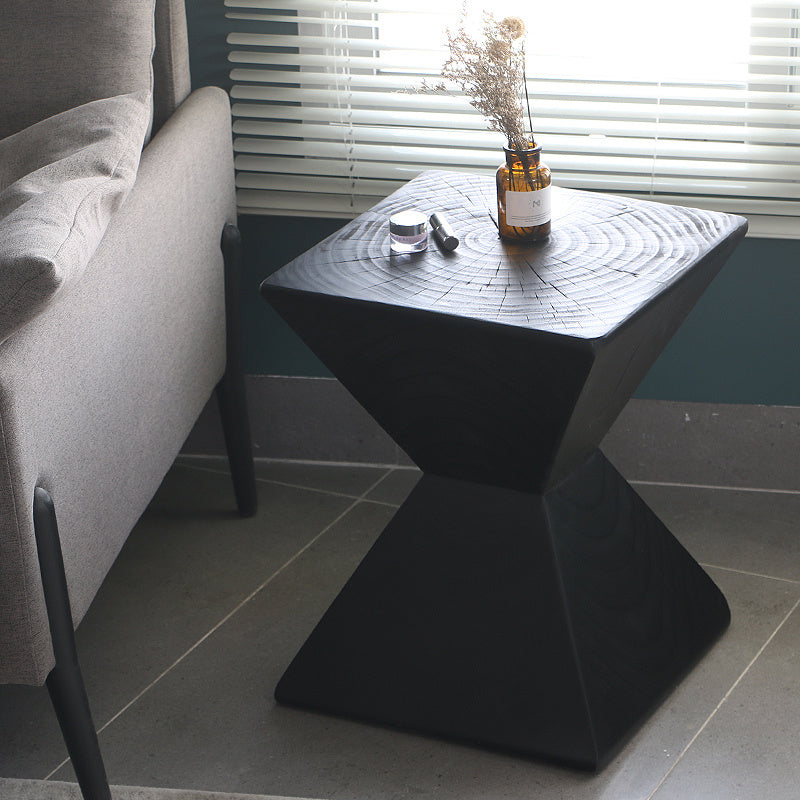 Shopi Vella black log sofa side table with geometric design next to gray sofa and window blinds