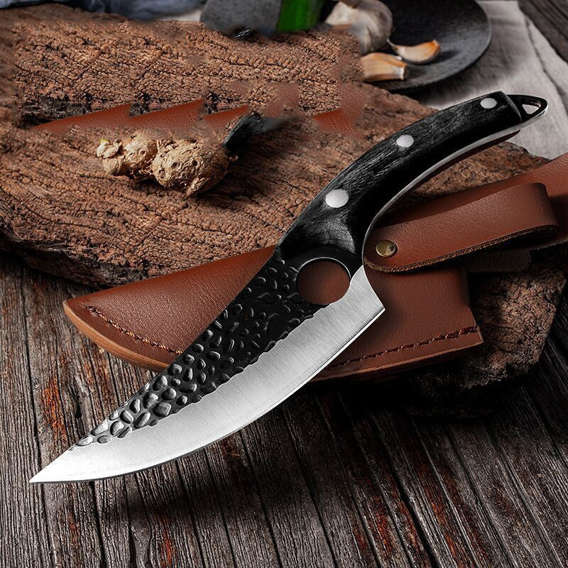 Shopi Vella meat cutting scimitar knife with hammered blade and ergonomic black handle on wooden surface