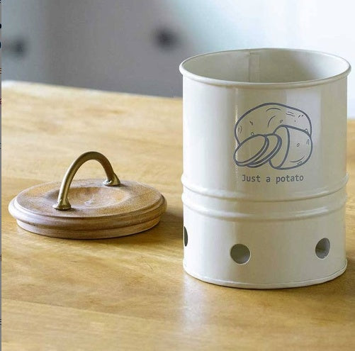 Shopi Vella metal potato storage bin with ventilation holes and wooden lid on wooden surface