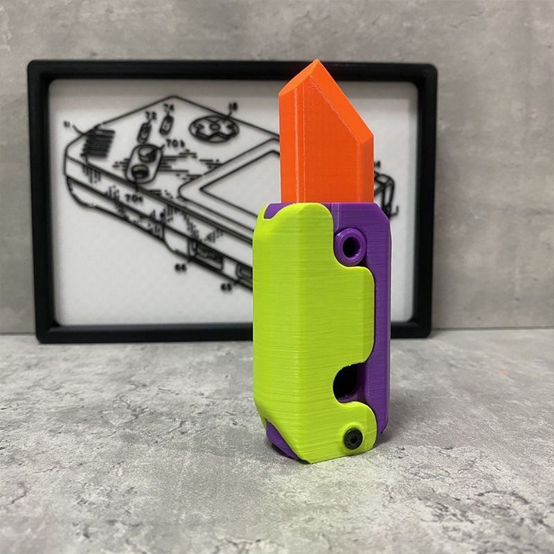 Shopi Vella mini 3D printing toy knife in bright orange, green, and purple colors on a gray surface