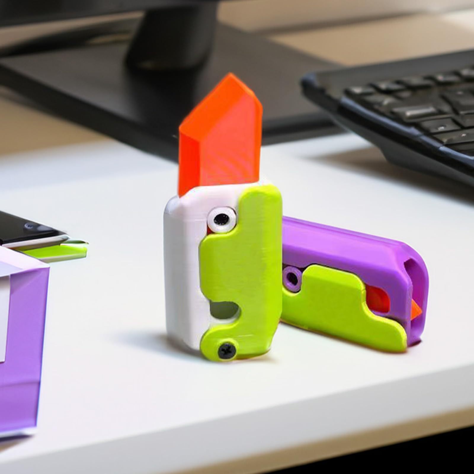 Shopi Vella mini 3D printing toy knife in bright colors on a white desk with keyboard nearby