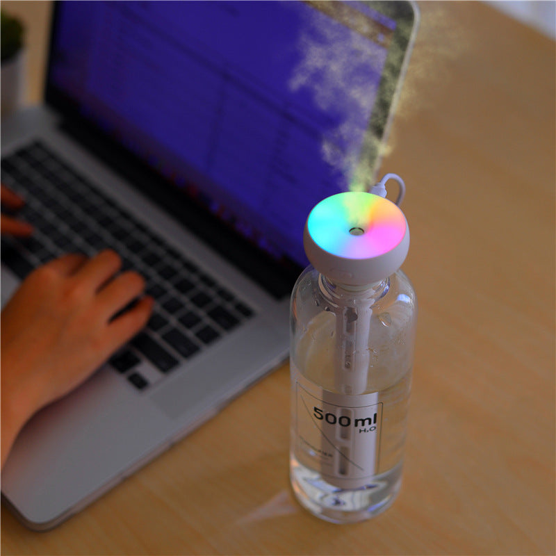 Shopi Vella mini USB humidifier with colorful LED light attached to water bottle near laptop
