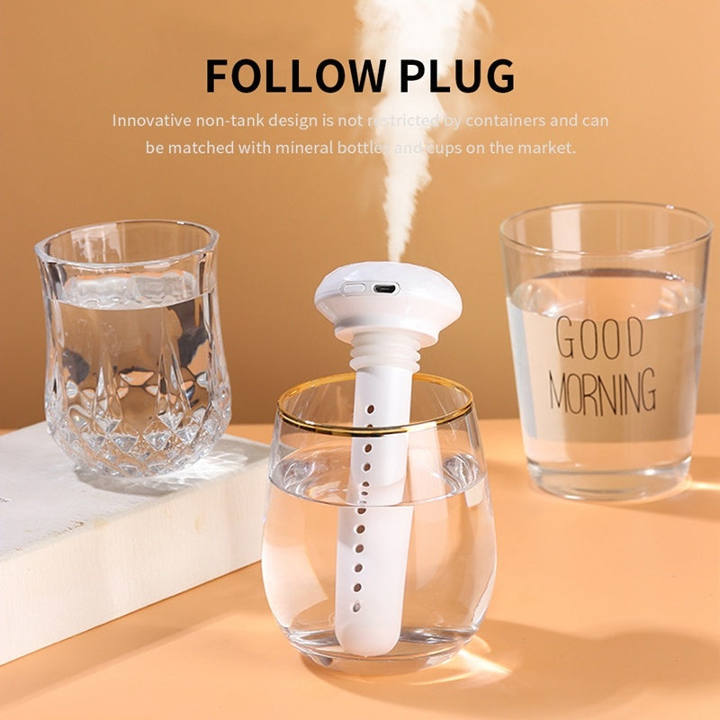 Shopi Vella mini USB humidifier in white placed inside a glass releasing mist on beige table