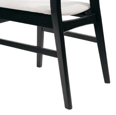 Close-up of black wooden legs and white cushion of modern dining chair set