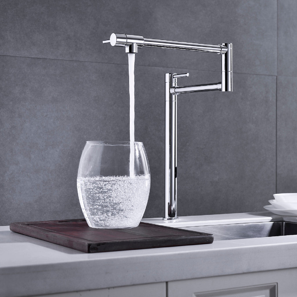 Shopi Vella modern folding sink faucet in chrome filling a glass with water over kitchen sink