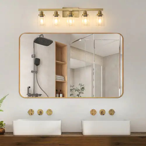 Modern gold vanity light fixture with five glass bulbs above double sink bathroom mirror