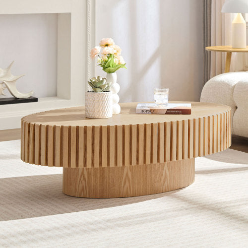 Shopi Vella modern handmade drum coffee table in light wood with decorative flowers and books on top