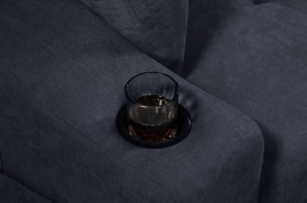 Close-up of dark gray modern sectional sofa with hidden compartments, featuring a built-in cup holder with a glass