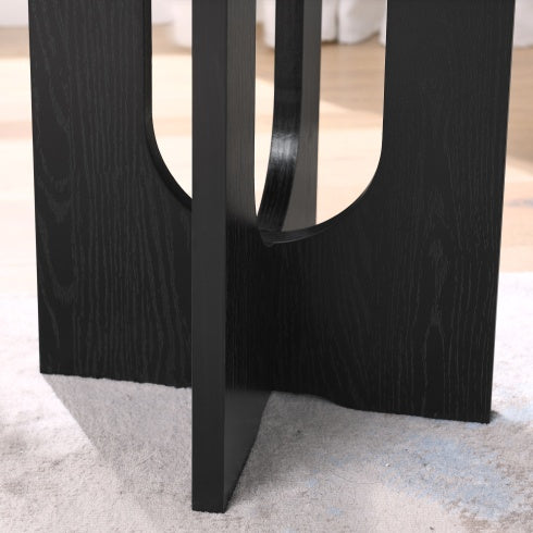 Close-up of black modern solid wood coffee table base showing wood grain texture and geometric design