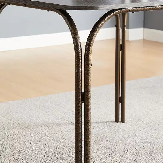 Close-up of metal legs supporting modern wooden dining table set on carpeted floor