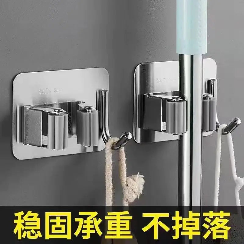Stainless steel mop and broom storage organizer mounted on wall holding handles securely
