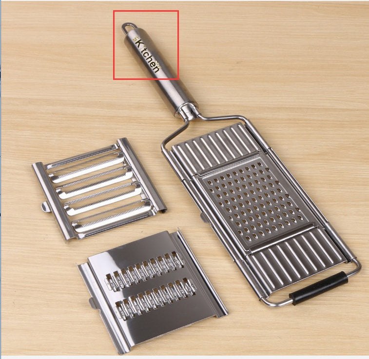 Shopi Vella multi-purpose grater and peeler with stainless steel handle and interchangeable blades on wooden surface