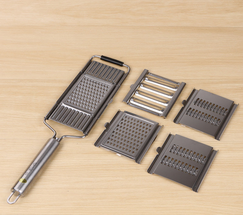 Shopi Vella multi-purpose grater and peeler set with interchangeable stainless steel blades on wooden surface
