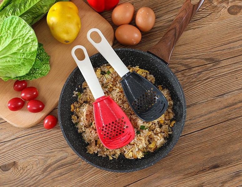 Shopi Vella multifunctional slotted cooking spoon in red and black resting on a frying pan with fried rice