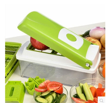 Shopi Vella multifunctional vegetable chopper with green lid and clear container alongside fresh sliced vegetables