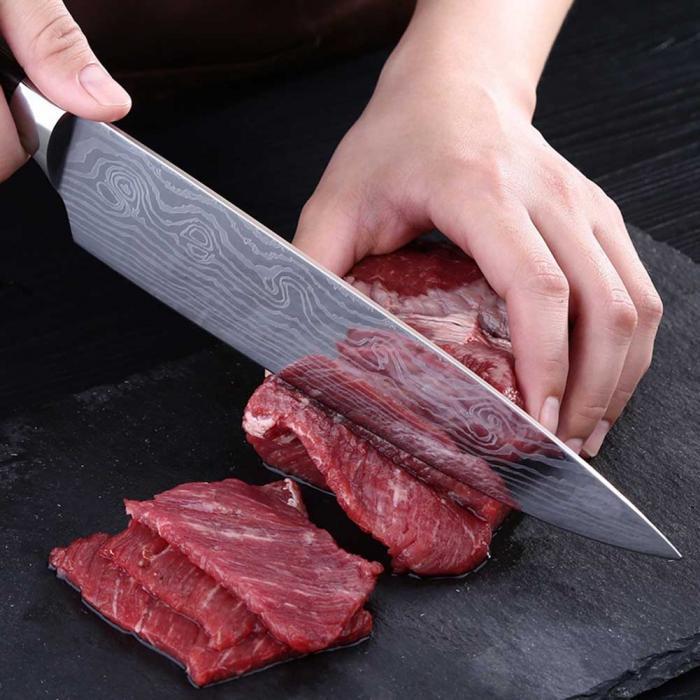 Shopi Vella multipurpose chef slicing knife cutting raw red meat on a black cutting board
