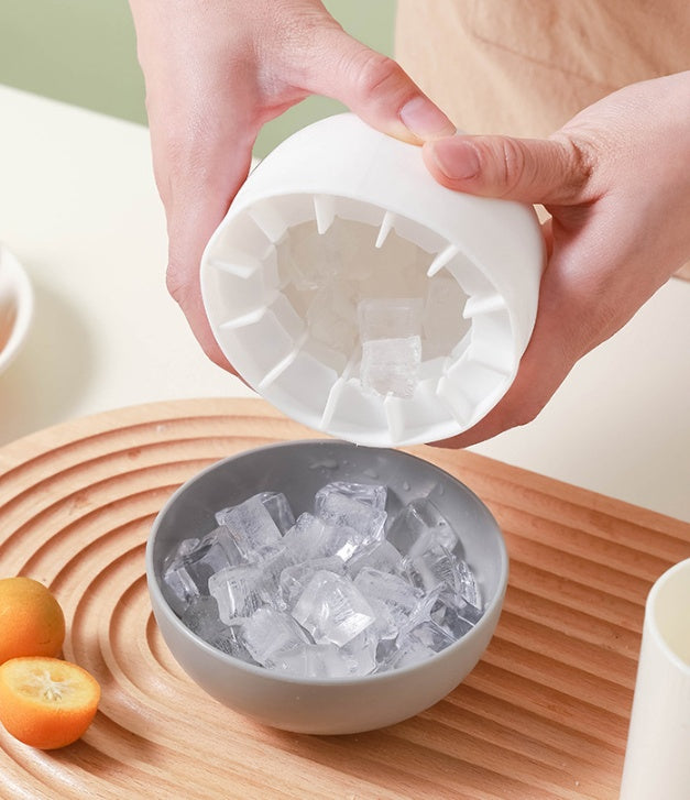 Shopi Vella mushroom ice cube mold releasing clear ice cubes into gray bowl on wooden tray