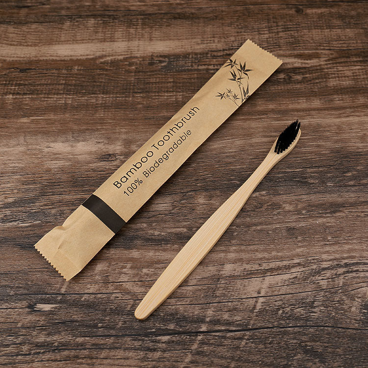 Natural bamboo toothbrushes soft bristle with biodegradable packaging on a wooden surface