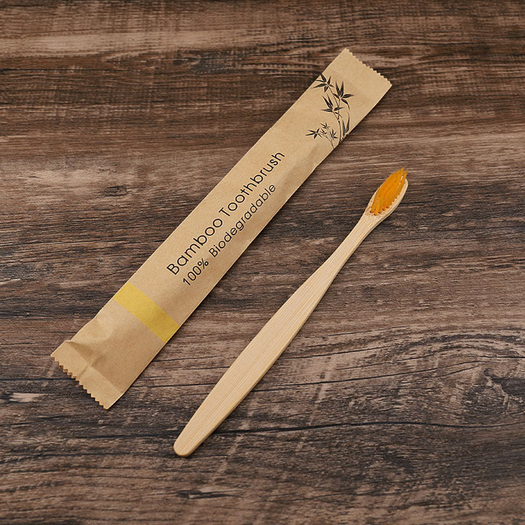 Natural bamboo toothbrushes soft bristle with biodegradable packaging on wooden surface