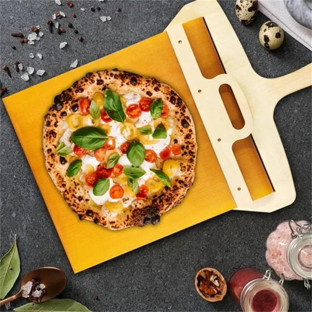 Shopi Vella non stick pizza transfer board with wooden handle holding a fresh Margherita pizza