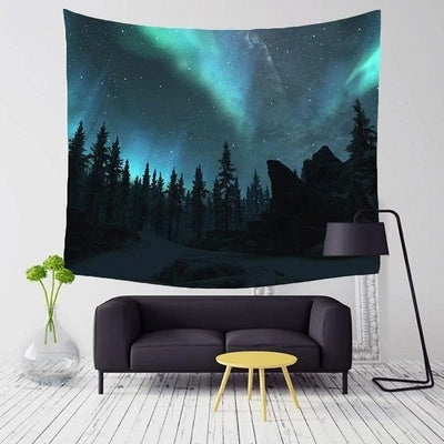 Shopi Vella northern lights wall tapestry with vibrant aurora borealis over forest hanging above modern black sofa