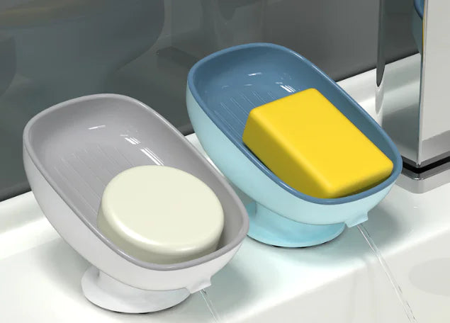 Octopus suction cup soap dish in gray and blue holding white and yellow soap bars on bathroom sink