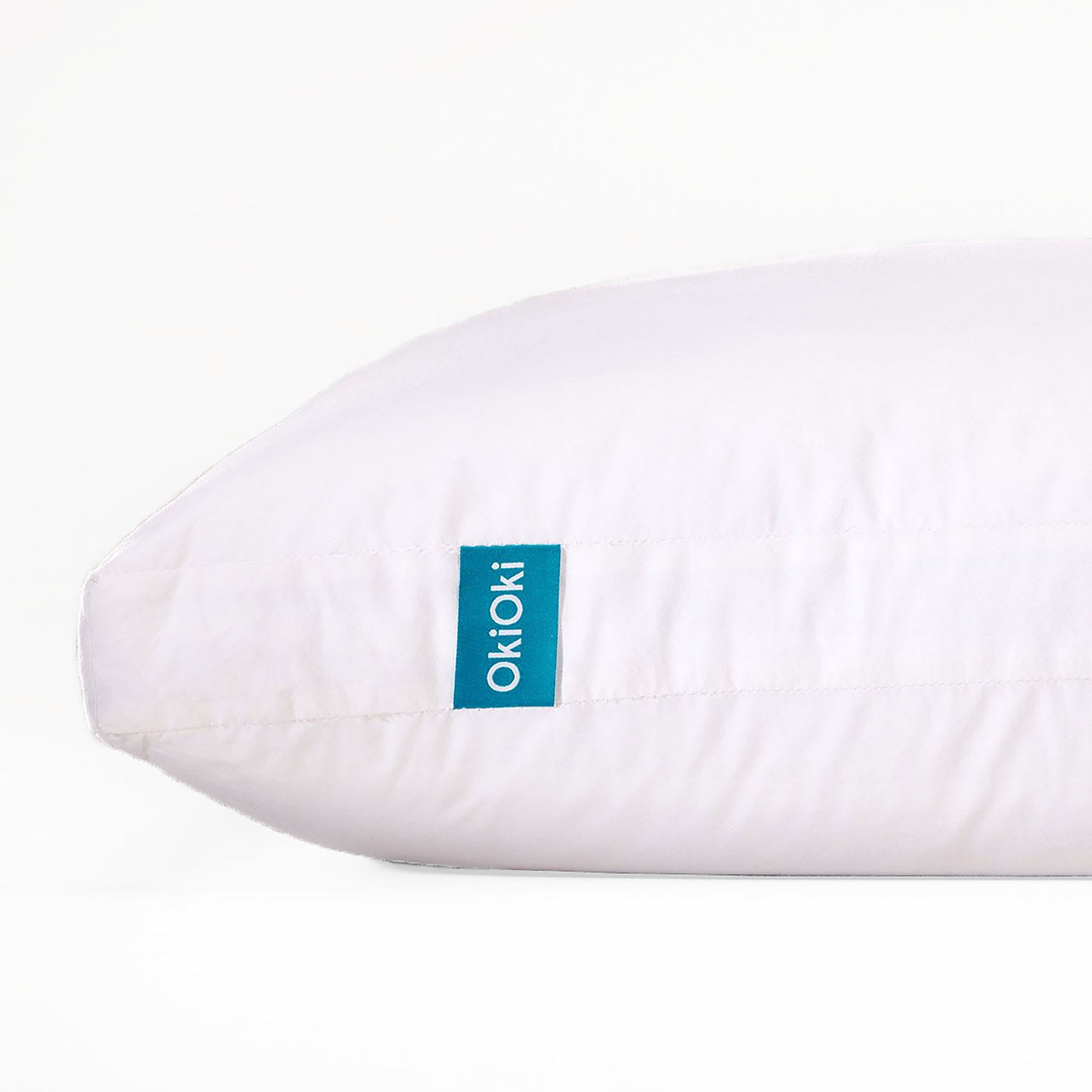 Shopi Vella white pillow case on soft supportive sleep pillow with blue OkioKi tag