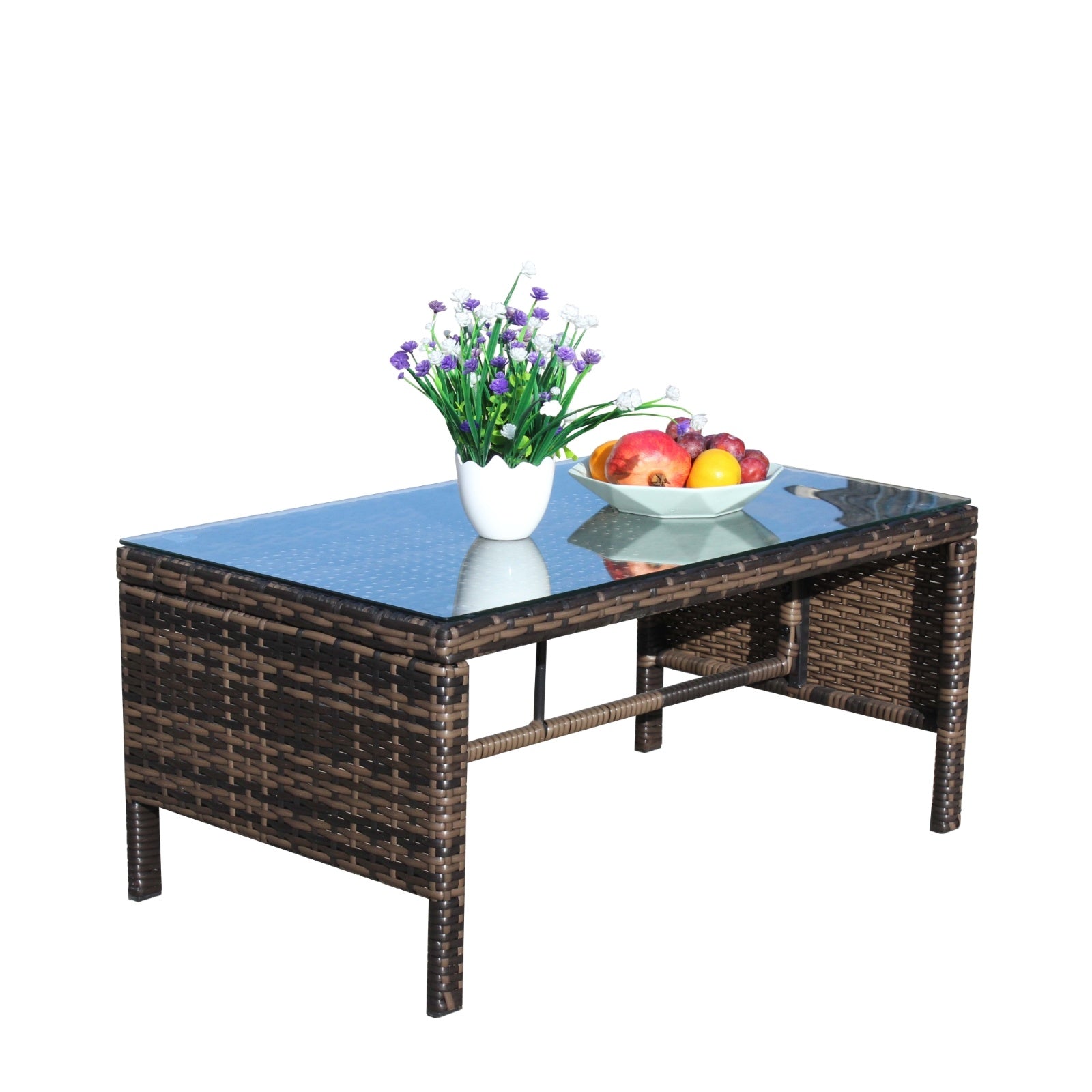 Shopi Vella outdoor patio coffee table with glass top and woven rattan design holding a vase with flowers and a fruit bowl