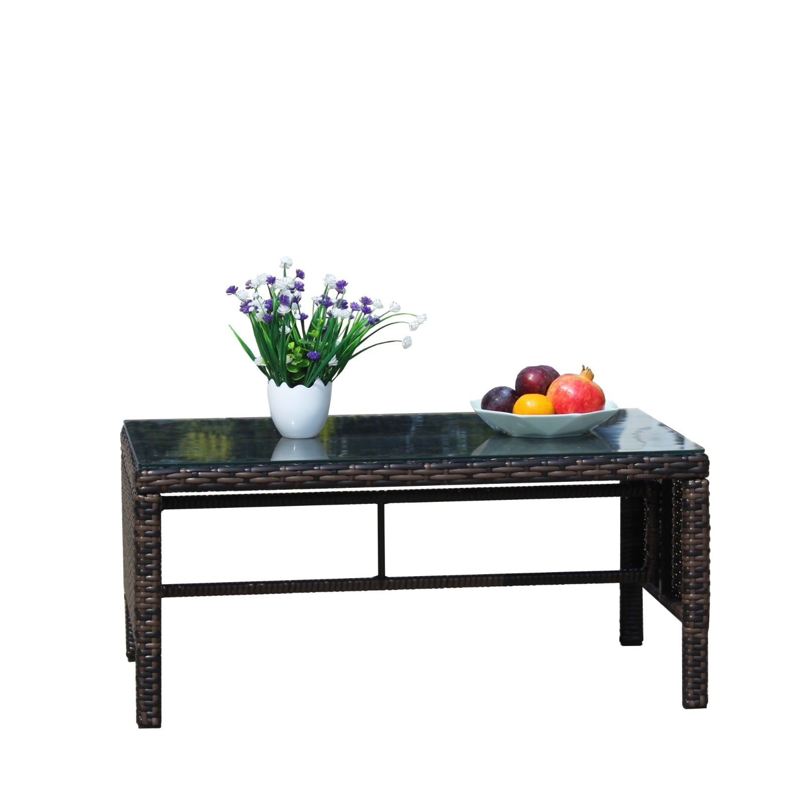 Shopi Vella outdoor patio coffee table with dark wicker frame and glass top decorated with flowers and fruit bowl