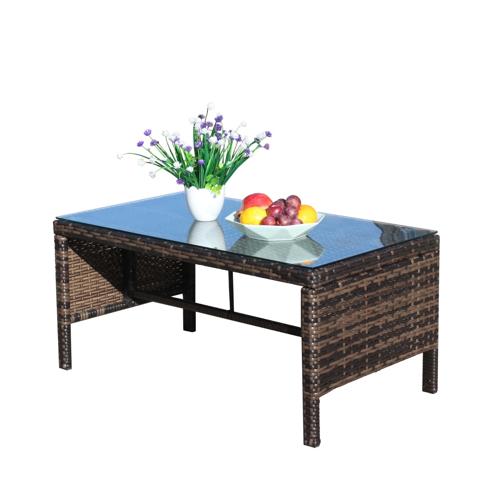 Shopi Vella outdoor patio coffee table with glass top and woven rattan design holding vase and fruit bowl