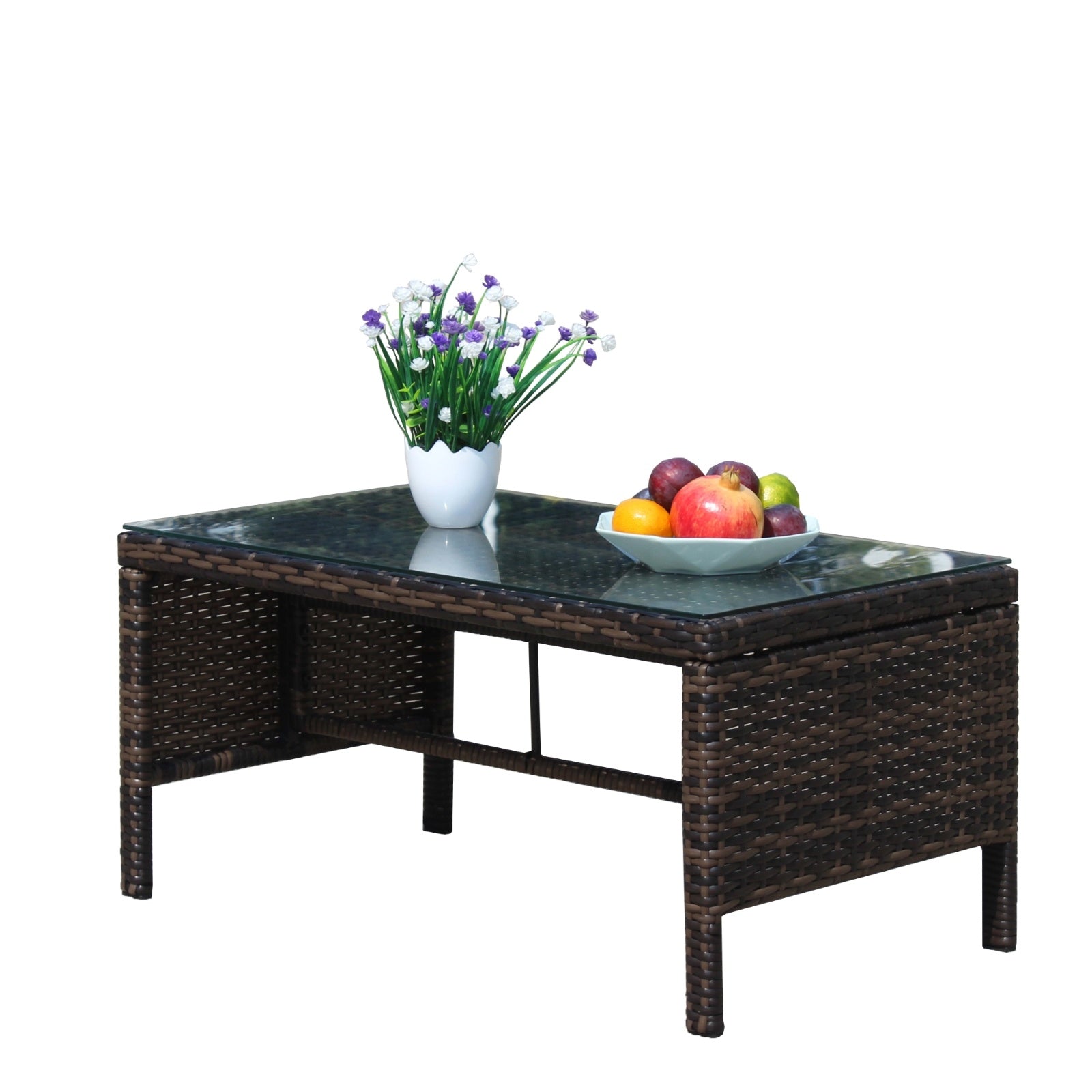 Shopi Vella outdoor patio coffee table with dark wicker frame and glass top, decorated with flowers and fruit bowl