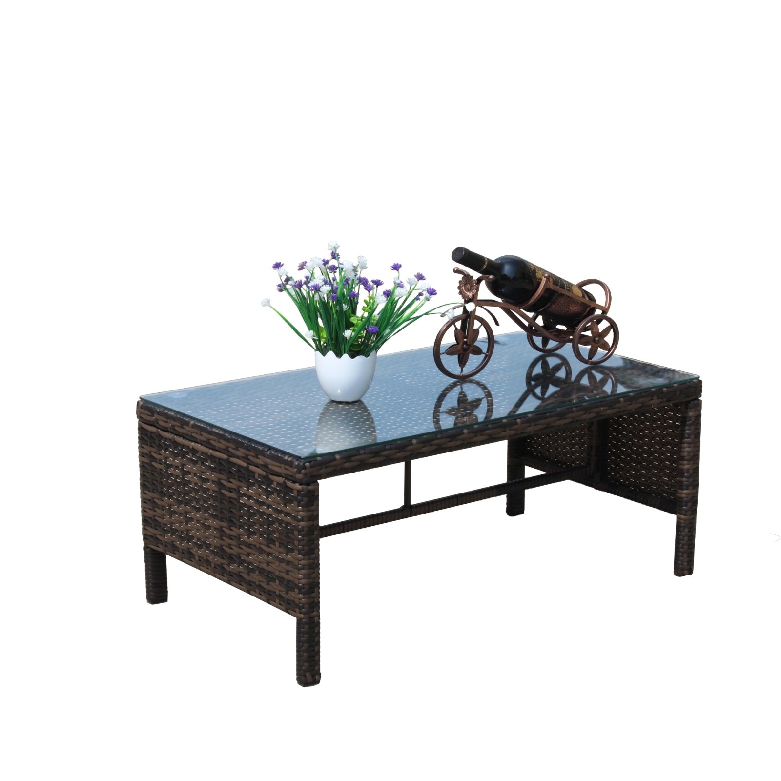 Shopi Vella outdoor patio coffee table with woven rattan base and glass top featuring decorative items