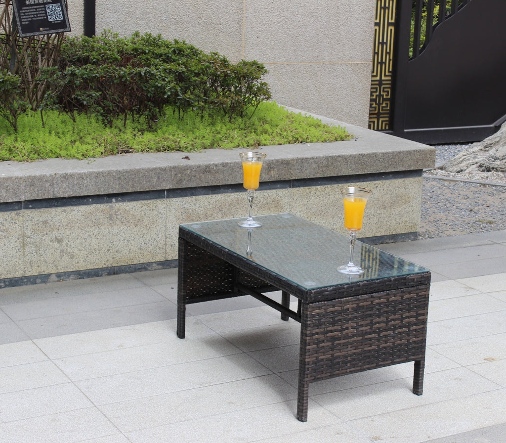 Shopi Vella outdoor patio coffee table with glass top and dark woven rattan design on tiled patio
