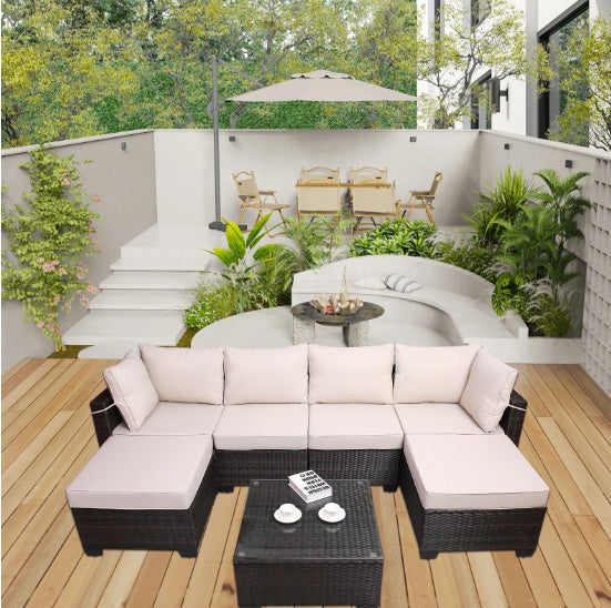 Outdoor sofa patio furniture set with beige cushions and black wicker frame on wooden deck