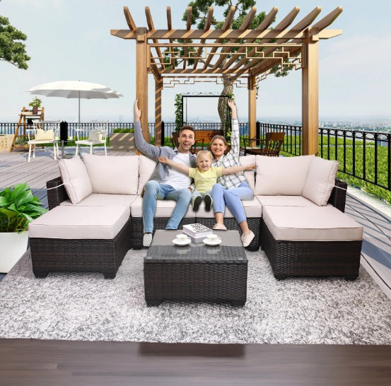 Outdoor sofa patio furniture set with beige cushions and woven dark brown frame on deck