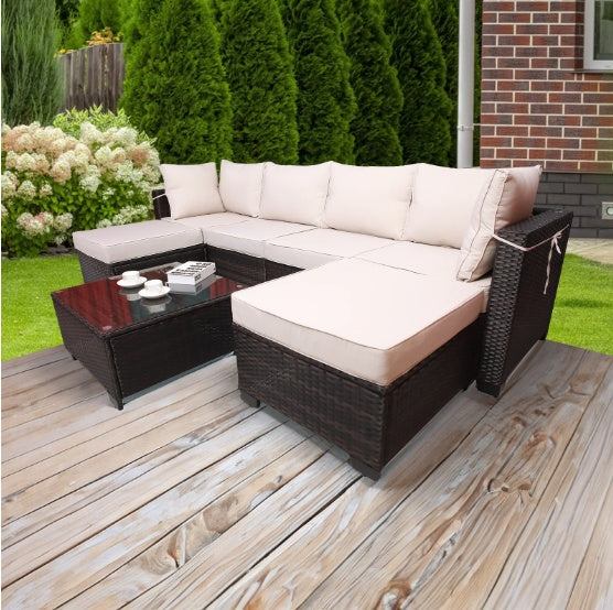 Outdoor sofa patio furniture with beige cushions and dark wicker frame on wooden deck