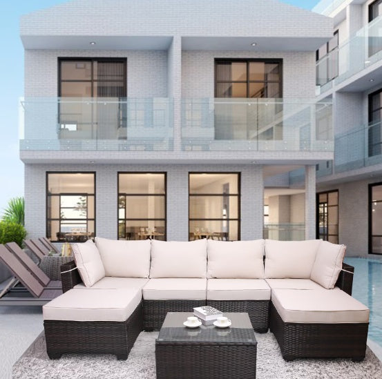 Outdoor sofa patio furniture with beige cushions and dark wicker frame set on modern patio