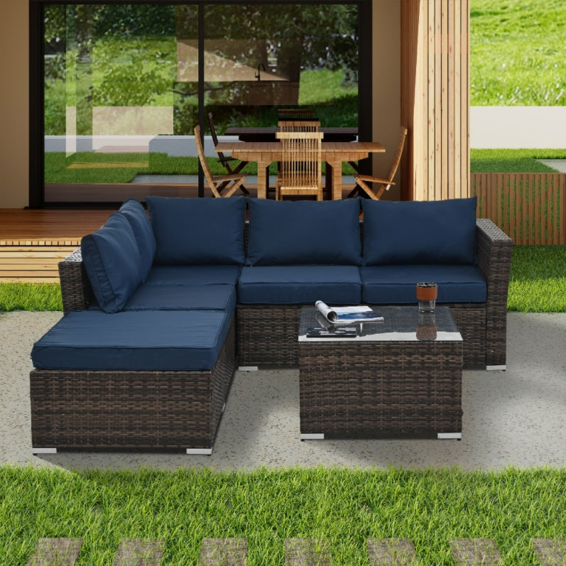 Shopi Vella outdoor wicker furniture with glass table featuring navy blue cushions in patio setting