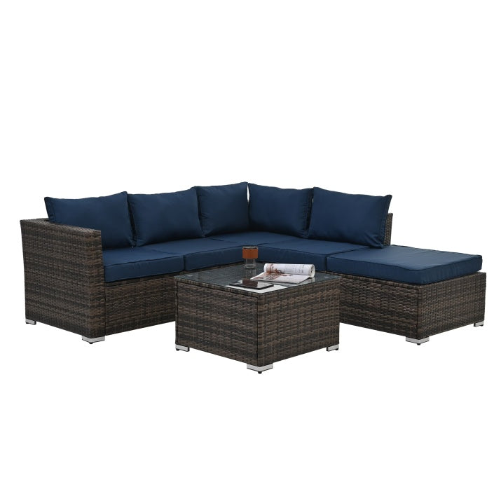 Outdoor wicker furniture with glass table and navy blue cushions by Shopi Vella for patio seating