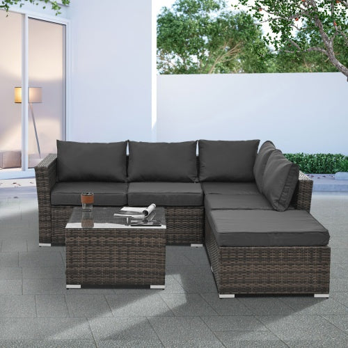 Shopi Vella outdoor wicker patio furniture set with dark cushions and glass-top coffee table on patio
