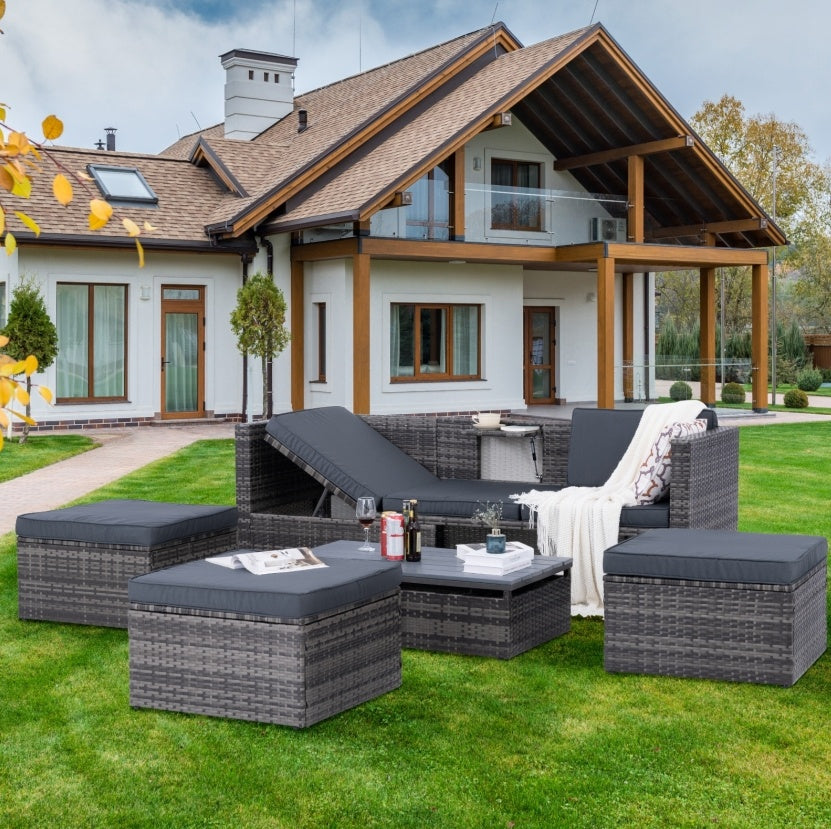 Shopi Vella outdoor wicker patio set with dark cushions on green lawn in front of modern house