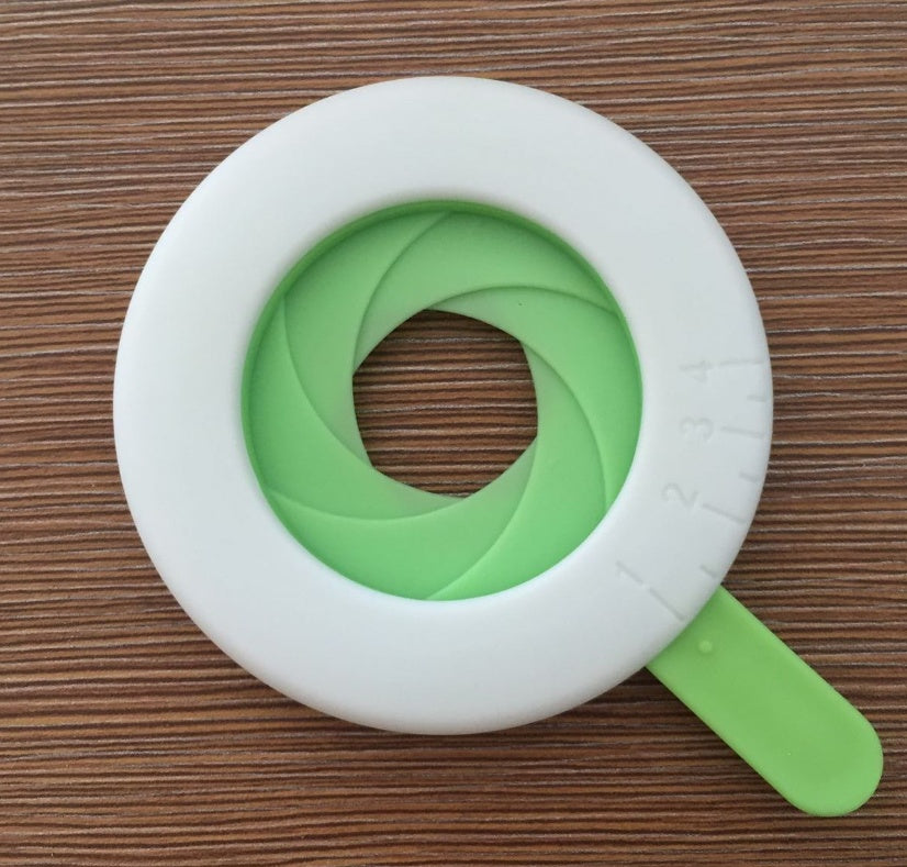 Shopi Vella kitchen storage pasta portion control tool in white and green on wooden background