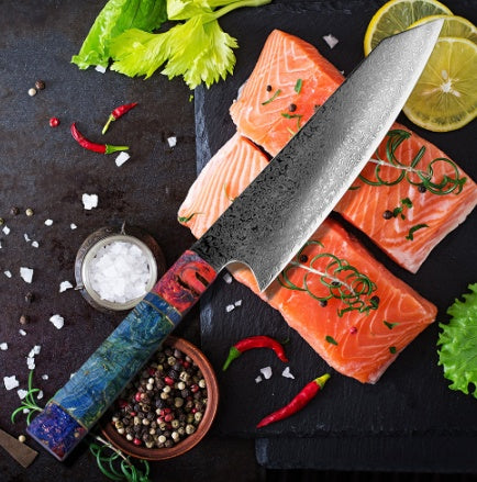 Shopi Vella pattern kitchen knife with decorative blade and colorful handle next to fresh salmon and spices