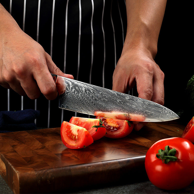 Shopi Vella pattern kitchen knife slicing fresh tomatoes on a wooden cutting board