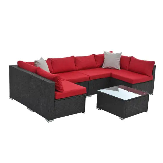 Black PE rattan patio furniture sectional sofa with red cushions and glass-top coffee table