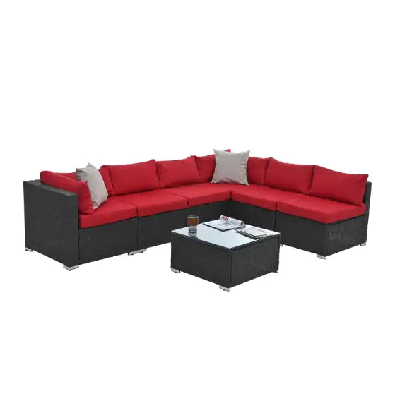 Modern black PE rattan patio furniture with red cushions and a glass-top coffee table