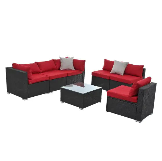 Black PE rattan patio furniture set with red cushions including sofa, loveseat, chair, and glass-top coffee table