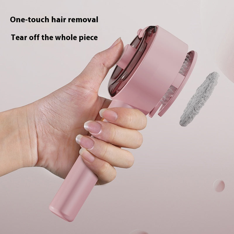 Hand holding pink pet hair remover brush with one-touch hair removal and tear-off feature