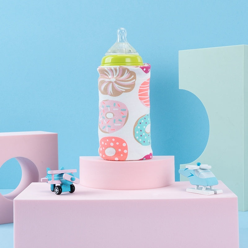Shopi Vella portable baby bottle warmer with colorful donut pattern on a baby bottle