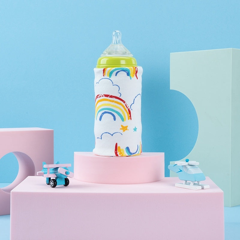 Shopi Vella portable baby bottle warmer with rainbow design on pastel pink and blue background